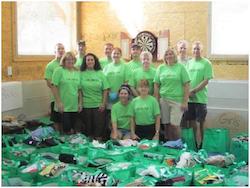 Employees with green shirts take group photo